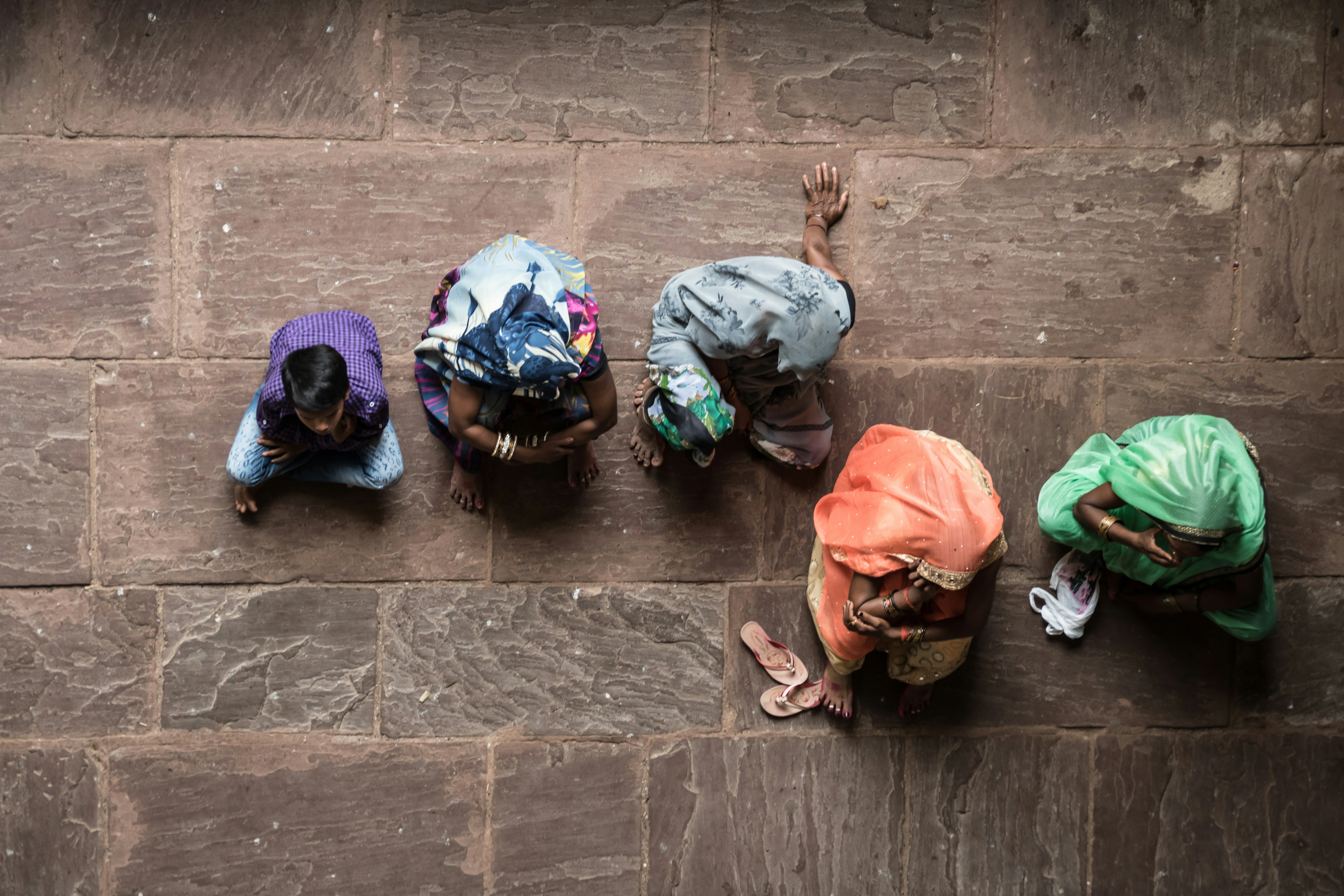 five person sitting on concrete floor